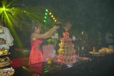 Une femme et un homme remplissent une pyramide de verres à champagne lors d'une réception festive.