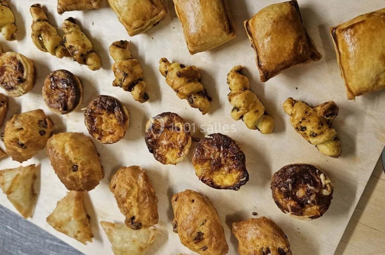 Assortiment de viennoiseries et feuilletés dorés disposés sur une feuille de papier cuisson.