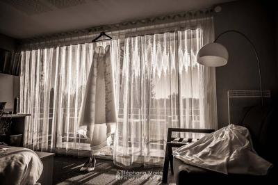 Salle de bain avec douche à l'italienne, carrelage effet brique, vasque blanche et miroir au mur.