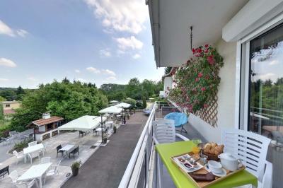 Salle de bain avec douche à l'italienne, carrelage effet brique, vasque blanche et miroir au mur.