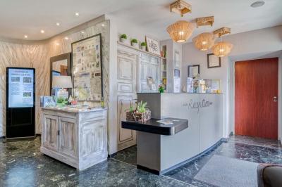 Salle de bain avec douche à l'italienne, carrelage effet brique, vasque blanche et miroir au mur.