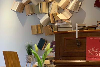 Salle de bain avec douche à l'italienne, carrelage effet brique, vasque blanche et miroir au mur.