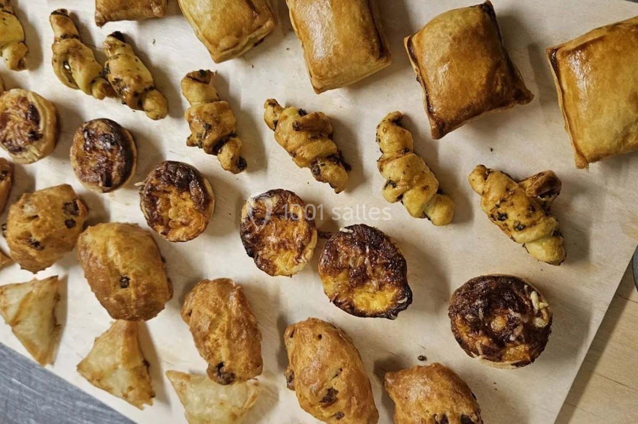 Assortiment de viennoiseries et feuilletés dorés disposés sur une feuille de papier cuisson.