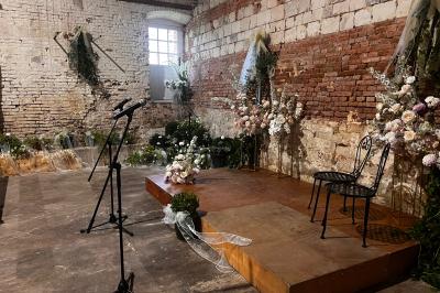 Miniature Scpa Visualproduction #10 Pièce montée en choux décorée de fleurs en sucre et de motifs en chocolat blanc, posée devant un mur de briques.