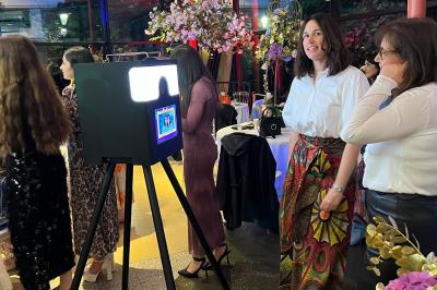 Miniature Scpa Visualproduction #8 Pièce montée en choux décorée de fleurs en sucre et de motifs en chocolat blanc, posée devant un mur de briques.