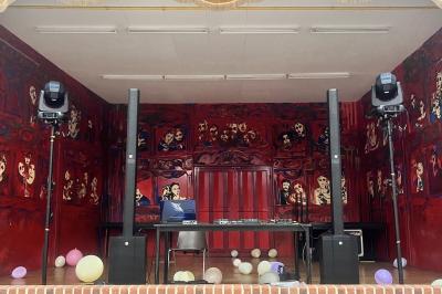 Deux faisceaux lumineux blancs traversent une salle avec des murs en pierre, éclairant un espace légèrement enfumé.