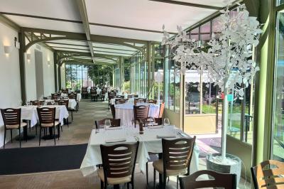 Chambre lumineuse avec lit double, bureau près de la fenêtre, cheminée décorative et télévision murale.