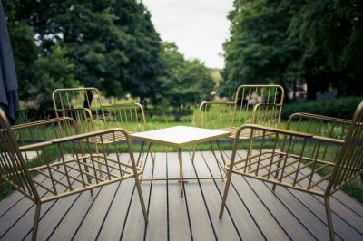 Chambre lumineuse avec lit double, bureau près de la fenêtre, cheminée décorative et télévision murale.