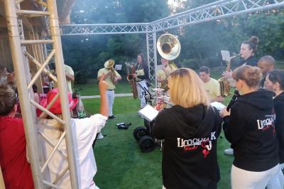 Groupe de personnes dansant dans une salle éclairée par des lumières colorées, avec un écran diffusant des images en arrière…