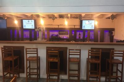 Groupe de personnes dansant dans une salle éclairée par des lumières colorées, avec un écran diffusant des images en arrière…