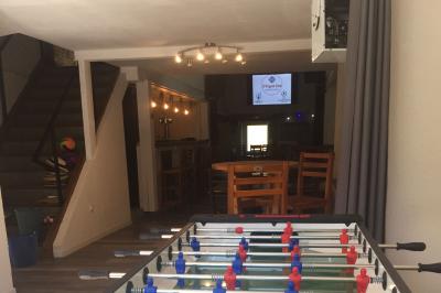 Groupe de personnes dansant dans une salle éclairée par des lumières colorées, avec un écran diffusant des images en arrière…