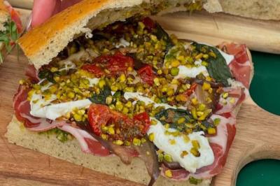 Deux verres de cocktails, l'un avec une tranche de citron, l'autre avec une tranche d'orange, tenus par deux mains.