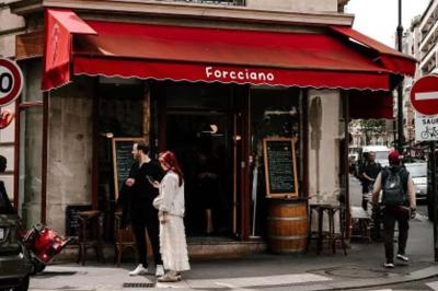 Deux verres de cocktails, l'un avec une tranche de citron, l'autre avec une tranche d'orange, tenus par deux mains.