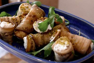 Deux verres de cocktails, l'un avec une tranche de citron, l'autre avec une tranche d'orange, tenus par deux mains.