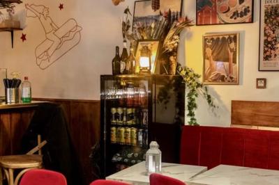 Deux verres de cocktails, l'un avec une tranche de citron, l'autre avec une tranche d'orange, tenus par deux mains.