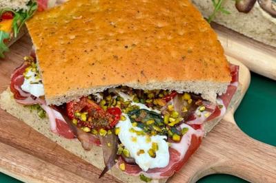 Deux verres de cocktails, l'un avec une tranche de citron, l'autre avec une tranche d'orange, tenus par deux mains.