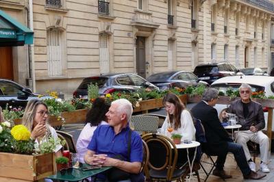 Deux verres de cocktails, l'un avec une tranche de citron, l'autre avec une tranche d'orange, tenus par deux mains.