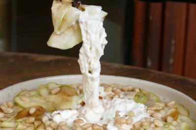 Deux verres de cocktails, l'un avec une tranche de citron, l'autre avec une tranche d'orange, tenus par deux mains.