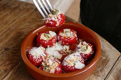Deux verres de cocktails, l'un avec une tranche de citron, l'autre avec une tranche d'orange, tenus par deux mains.