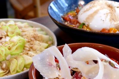 Deux verres de cocktails, l'un avec une tranche de citron, l'autre avec une tranche d'orange, tenus par deux mains.