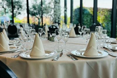 Étang entouré d'arbres et de buissons sous la neige, avec un lampadaire et des bancs dans un paysage hivernal.