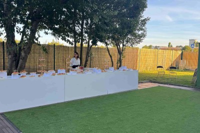 Salle de réception décorée avec des fleurs blanches, des tables élégantes et un éclairage rose tamisé.