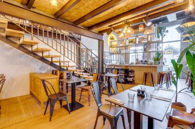 Une pâte à pizza soulevée pour montrer son élasticité, avec une garniture de sauce tomate et fromage visible.