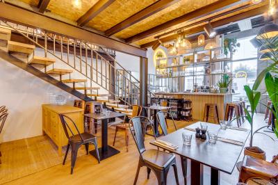 Préparation d'une pizza avec des mains ajoutant des tranches de chorizo sur une pâte garnie de sauce tomate et fromage râpé.