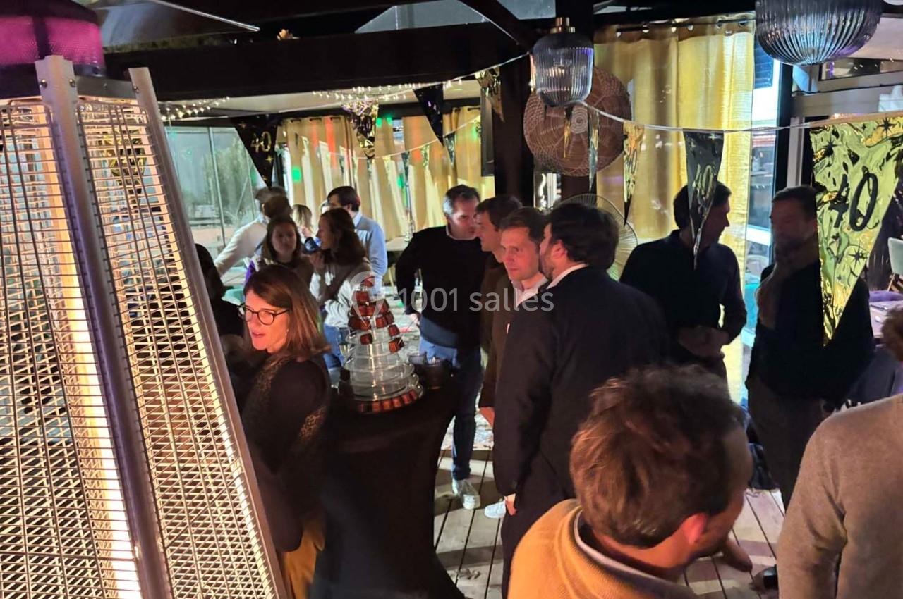 Groupe de personnes discutant dans un espace intérieur décoré avec des lumières et des éléments festifs.