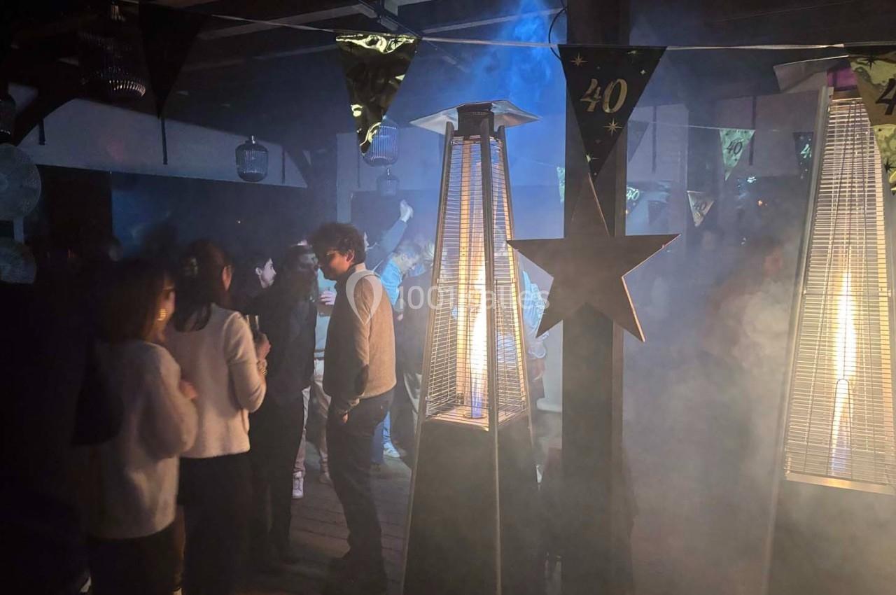 Personnes rassemblées dans une ambiance festive avec des chauffages extérieurs et des décorations pour un 40e anniversaire.