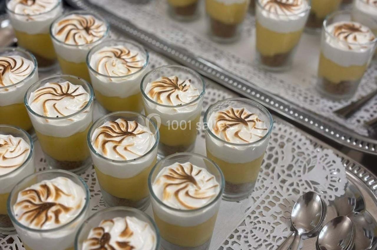 Verrines de dessert avec mousse citronnée, meringue dorée et biscuits, présentées sur un plateau argenté.