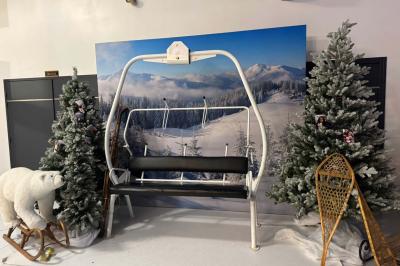 Voiture ancienne blanche stationnée devant une véranda moderne, entourée de végétation et d'arbres.