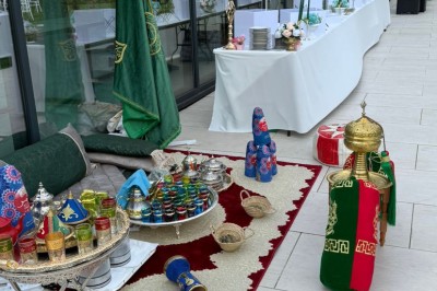 Voiture ancienne blanche stationnée devant une véranda moderne, entourée de végétation et d'arbres.