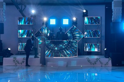 Voiture ancienne blanche stationnée devant une véranda moderne, entourée de végétation et d'arbres.