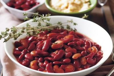 Plat de feuilles de légumes mijotées dans une sauce épicée, présenté dans une assiette blanche.