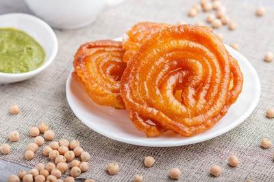 Plat de feuilles de légumes mijotées dans une sauce épicée, présenté dans une assiette blanche.