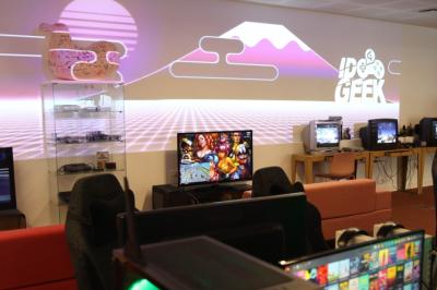 Salle de réunion lumineuse avec tables blanches, chaises orange et un tableau blanc sur pied.
