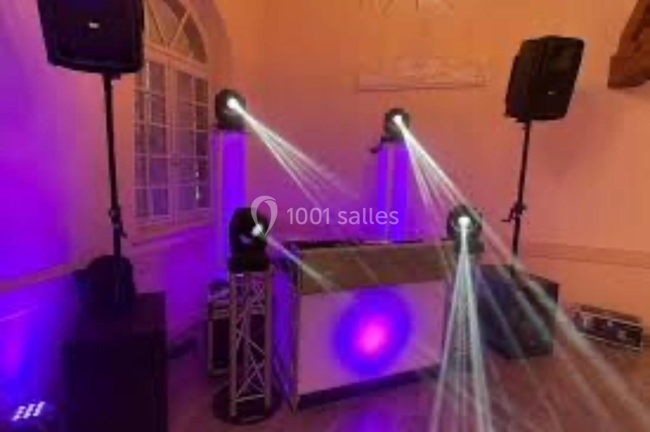 Installation de matériel de sonorisation et éclairage avec projecteurs lumineux dans une salle intérieure.