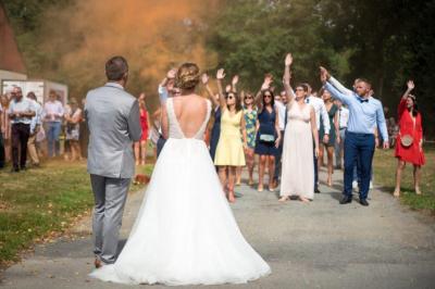 Des couples dansent sous des jeux de lumière colorés dans une salle sombre, créant une ambiance festive.