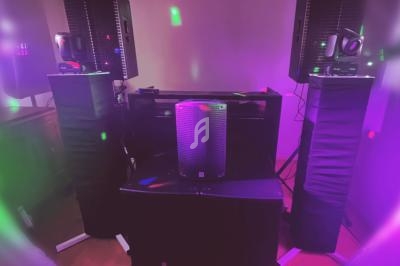 Enceintes et éclairages colorés installés dans une pièce sombre pour un événement ou une ambiance festive.