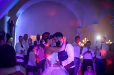 Deux enceintes sur trépieds et un caisson de basses posés sur un sol pavé devant une porte de garage.