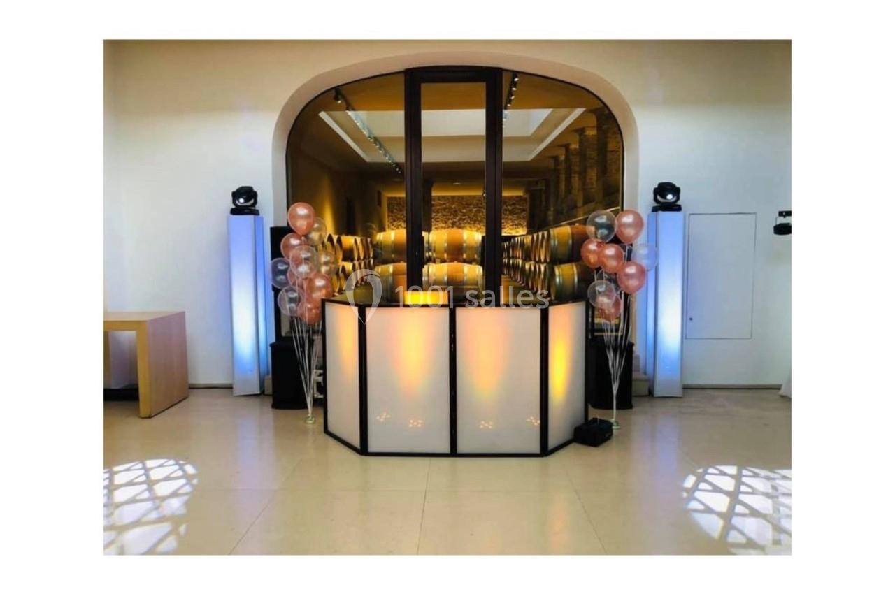 Comptoir lumineux décoré de ballons dans une salle moderne avec éclairage tamisé et sol en carrelage clair.