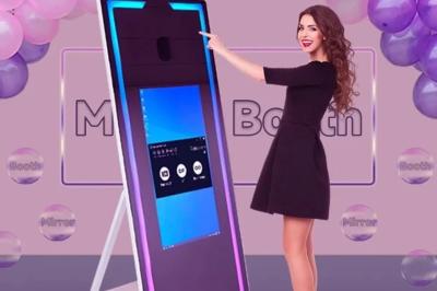 Deux personnes déguisées posent devant un smartphone affichant leur photo, accompagnées de deux autres en arrière-plan.