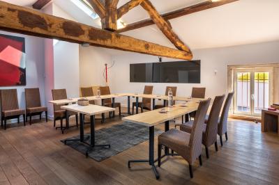 Personnes rassemblées dans une cour pavée avec un barbecue et une table de buffet en premier plan.