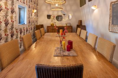 Personnes rassemblées dans une cour pavée avec un barbecue et une table de buffet en premier plan.