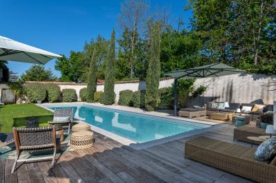 Personnes rassemblées dans une cour pavée avec un barbecue et une table de buffet en premier plan.