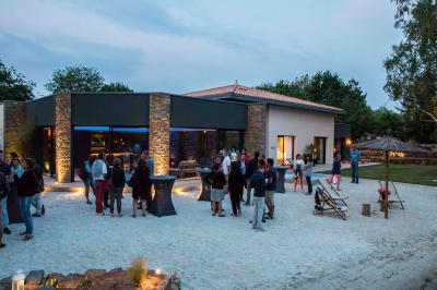 Un couple danse joyeusement dans une ambiance tamisée avec des lumières rouges en arrière-plan.