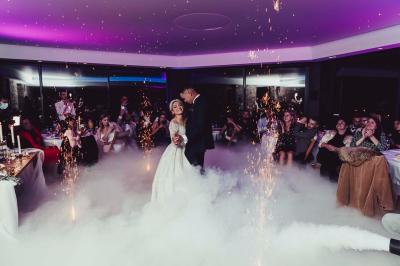 Un couple danse joyeusement dans une ambiance tamisée avec des lumières rouges en arrière-plan.