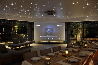 Un couple danse joyeusement dans une ambiance tamisée avec des lumières rouges en arrière-plan.