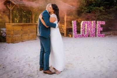 Un couple danse joyeusement dans une ambiance tamisée avec des lumières rouges en arrière-plan.